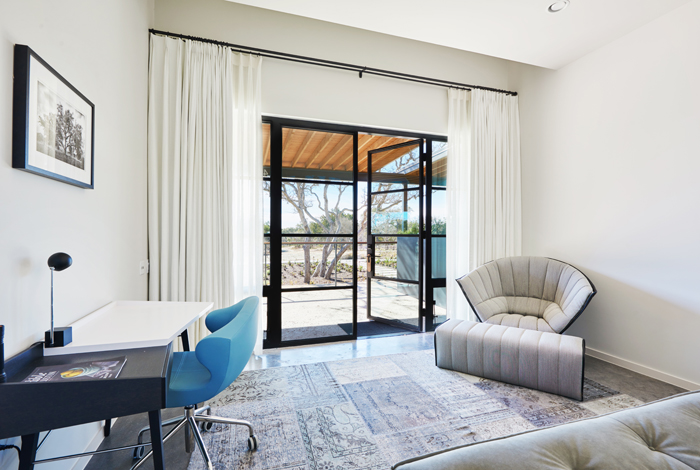 Guest room featuring steel and glass entry along with modern furnishings.